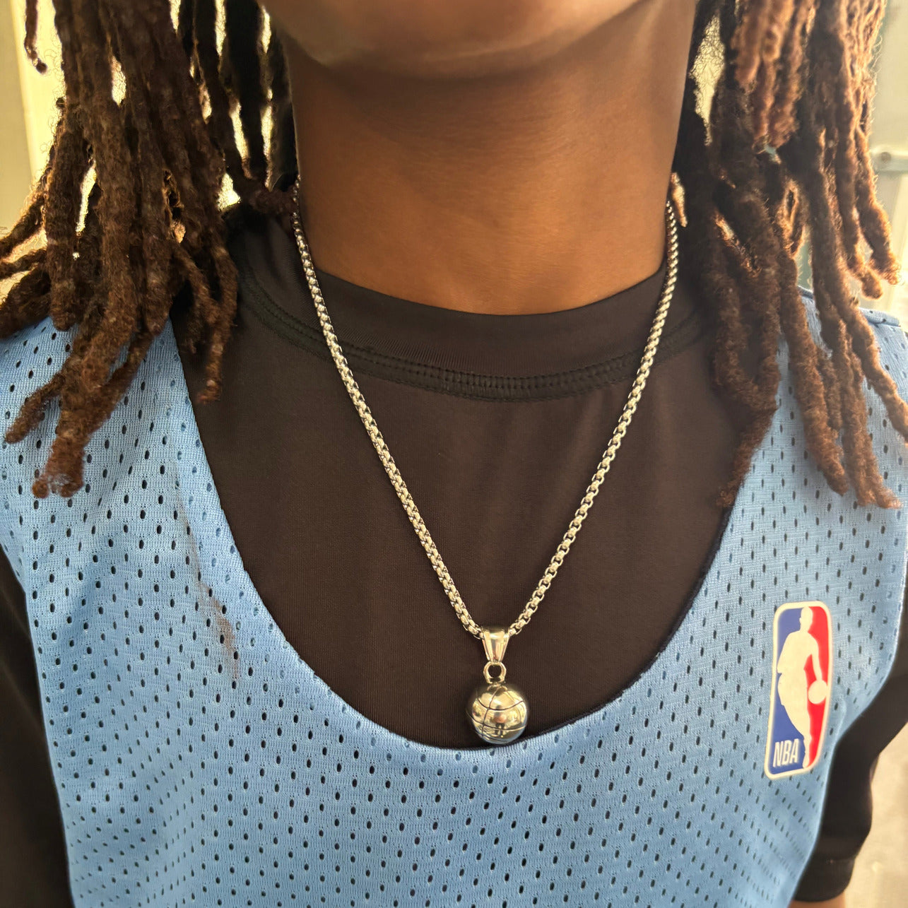 3D basketball pendant necklace worn on silver chain with basketball jersey and NBA logo visible