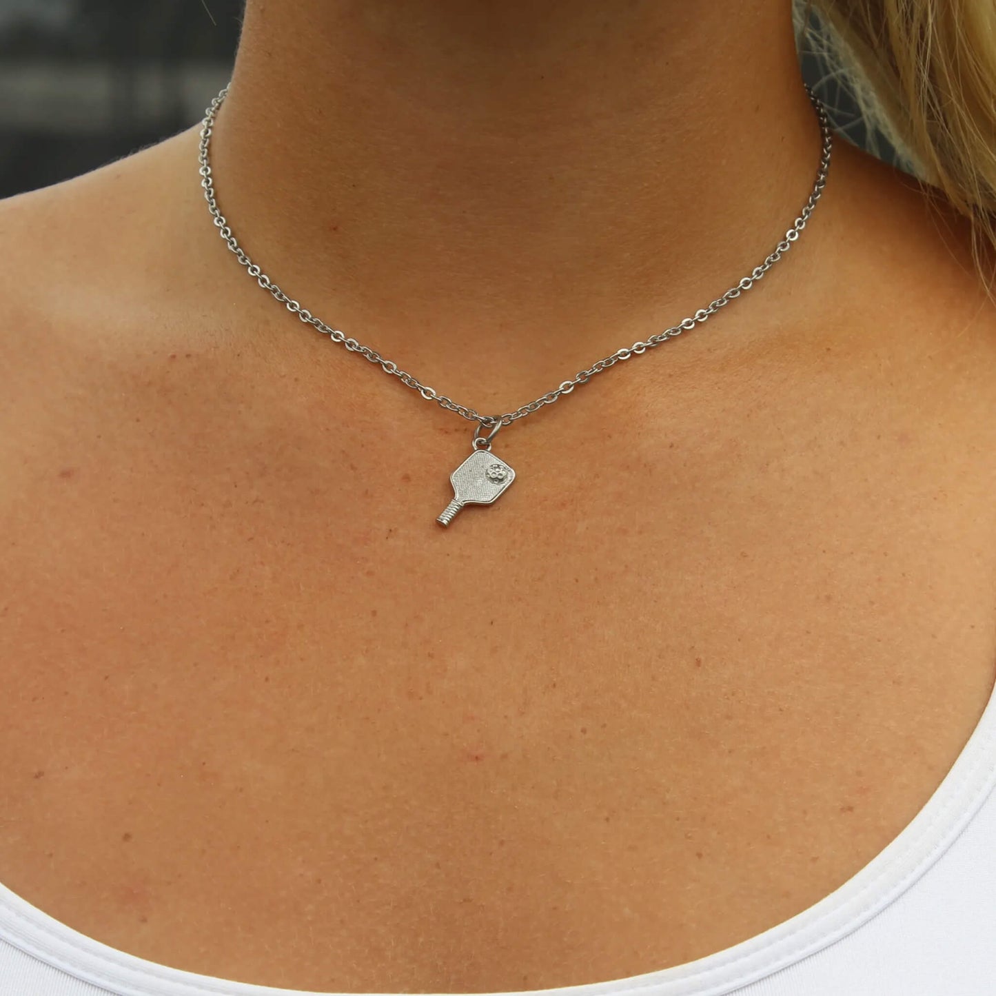 Silver pickleball paddle pendant necklace on a woman’s neck with 2.5mm link chain and lobster clasp