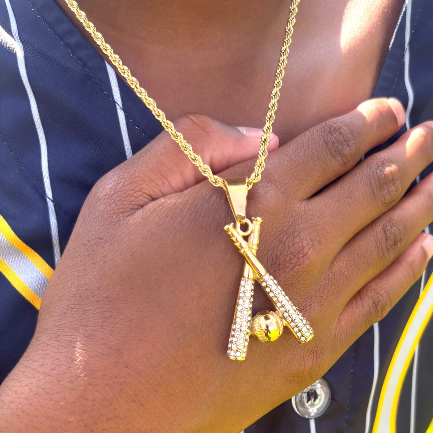 Gold studded baseball bats pendant and chain necklace with cubic zirconia stones worn on neck