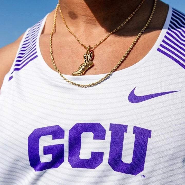 Gold winged running shoe pendant on chain necklace worn on athlete's neck with white and purple GCU sports jersey