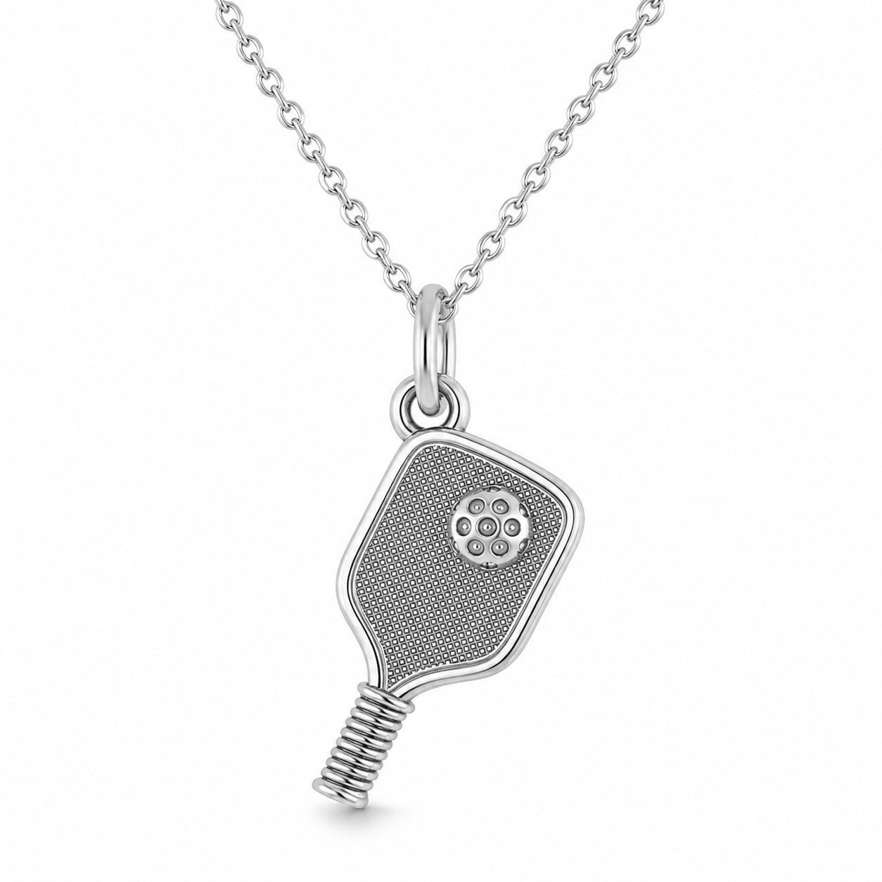A silver pickleball pendant necklace on a delicate silver chain, set against a plain white background.