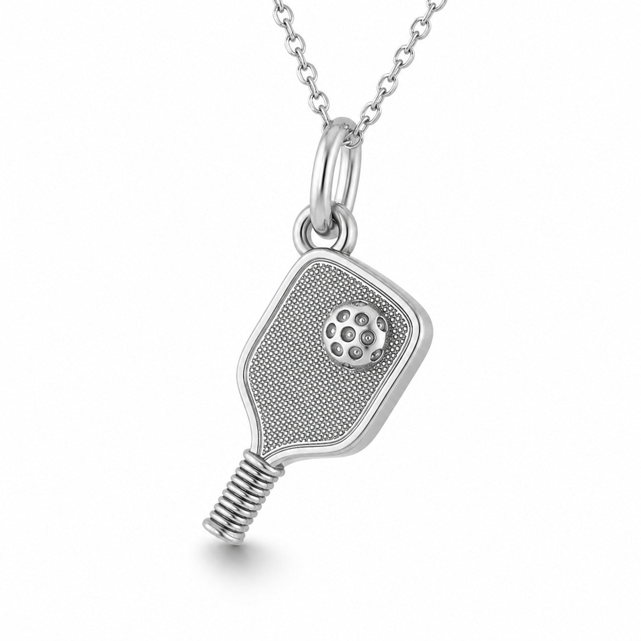 A silver pendant pickleball necklace shaped like a paddle racket, featuring a textured face, a small circular stud detail, and a coiled handle, suspended from a delicate silver chain on a white background.
