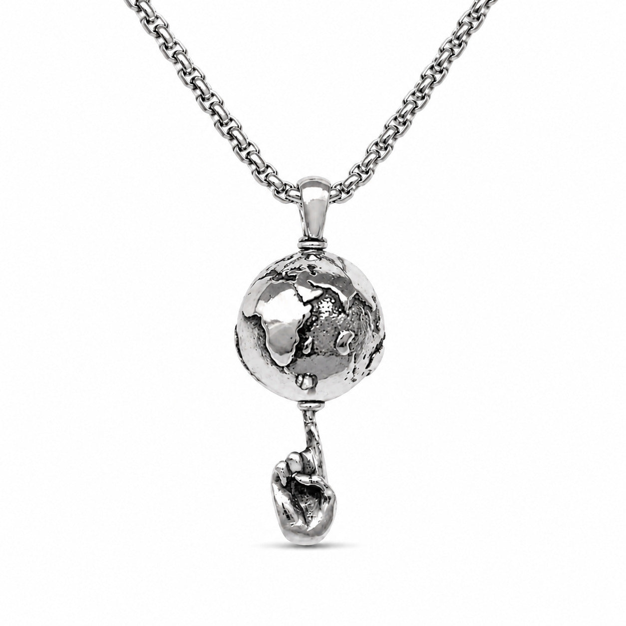 A silver-toned necklace featuring a detailed globe pendant that holds a small heart-shaped charm dangling below, set against a plain white background.